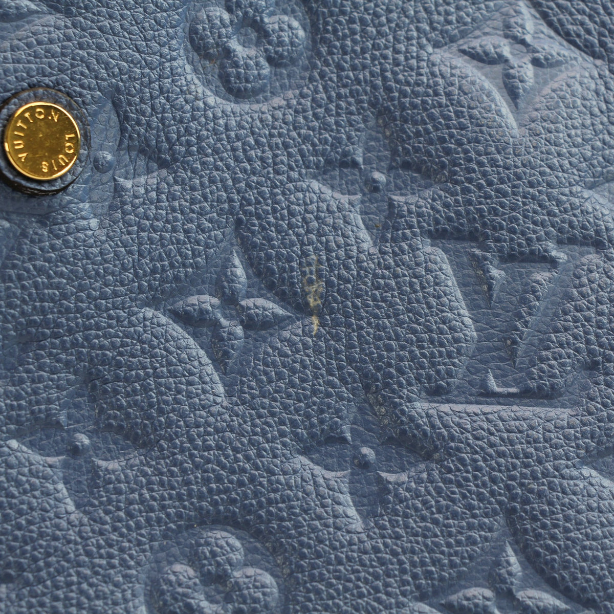 Blue Louis Vuitton Montaigne MM monogram Empreinte leather handbag with gold hardware and structured design.