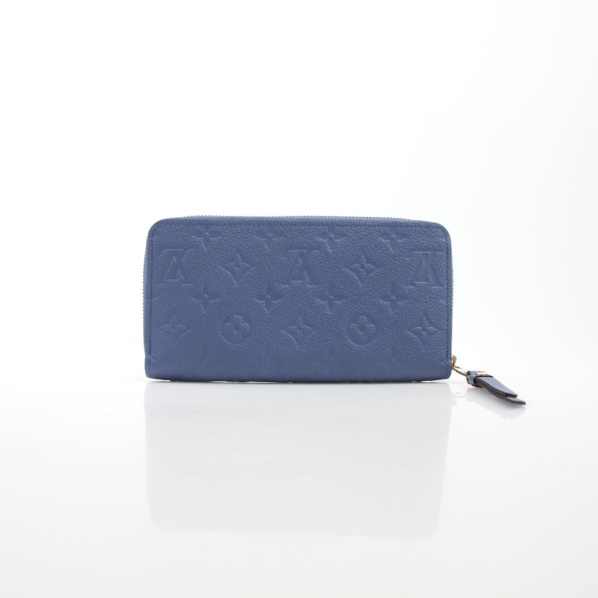 Louis Vuitton Monogram Empreinte Zippy Wallet in Bleu Infini with gold-tone hardware, showcasing embossed leather and zip closure.