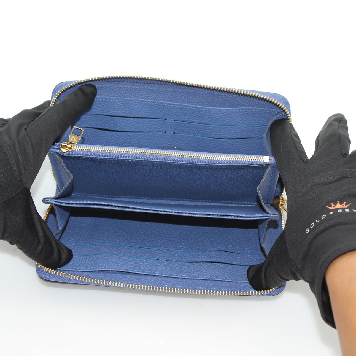 Louis Vuitton Monogram Empreinte Zippy Wallet in Bleu Infini with gold-tone zipper and embossed LV logo, showcasing luxurious leather design.