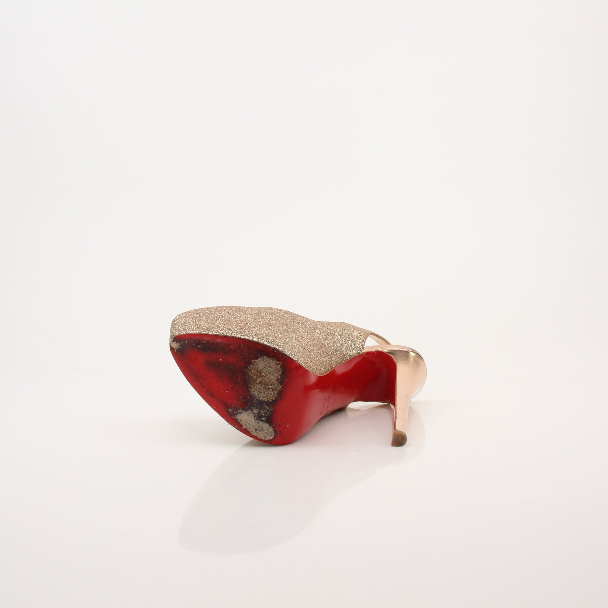 Christian Louboutin Daffodil sling heels with red soles and gold accents, stylishly displayed on a neutral background.