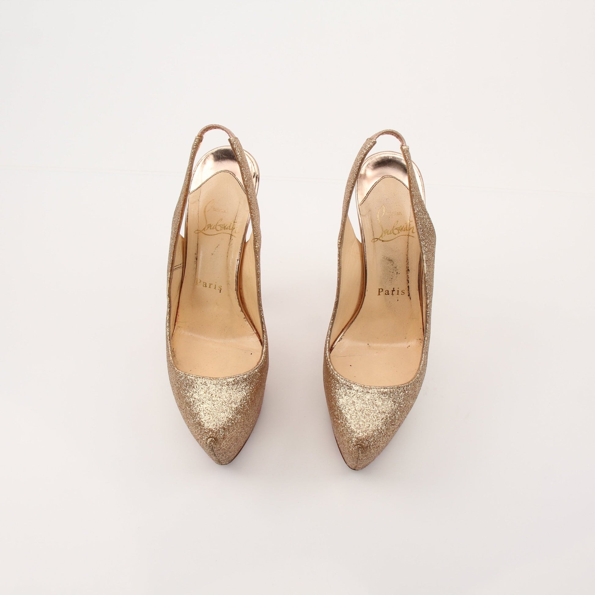 Christian Louboutin Daffodil sling heels with red soles, gold-tone strap, and elegant design, showcased on a neutral background.