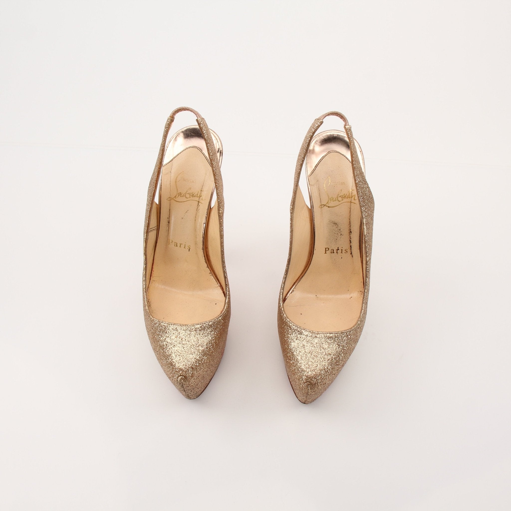 Christian Louboutin Daffodil sling heels with red soles, gold-tone strap, and elegant design, showcased on a neutral background.