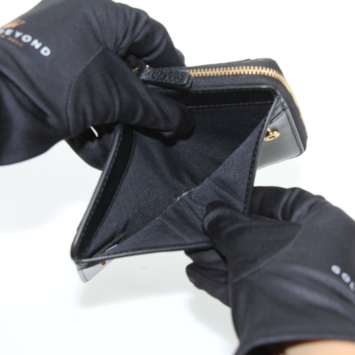 Black Marc Jacobs leather mini compact wallet with gold accents, featuring a sleek, slim design and multiple card slots.