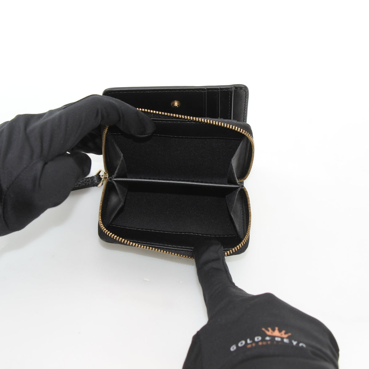 Black Marc Jacobs The Leather Mini Compact Wallet with gold-tone hardware, featuring a sleek leather finish and compact design.