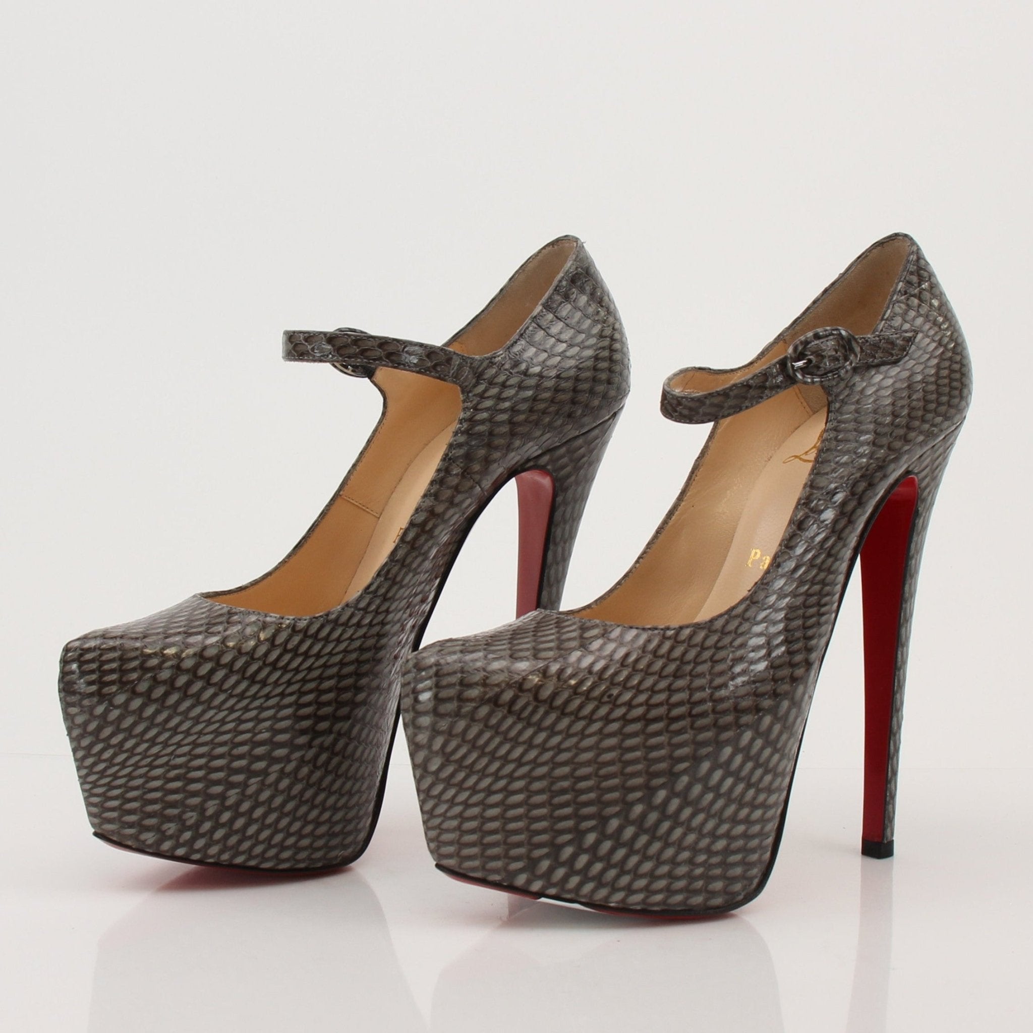Christian Louboutin snakeskin platform heels with red sole, featuring sleek design and high stiletto heel.