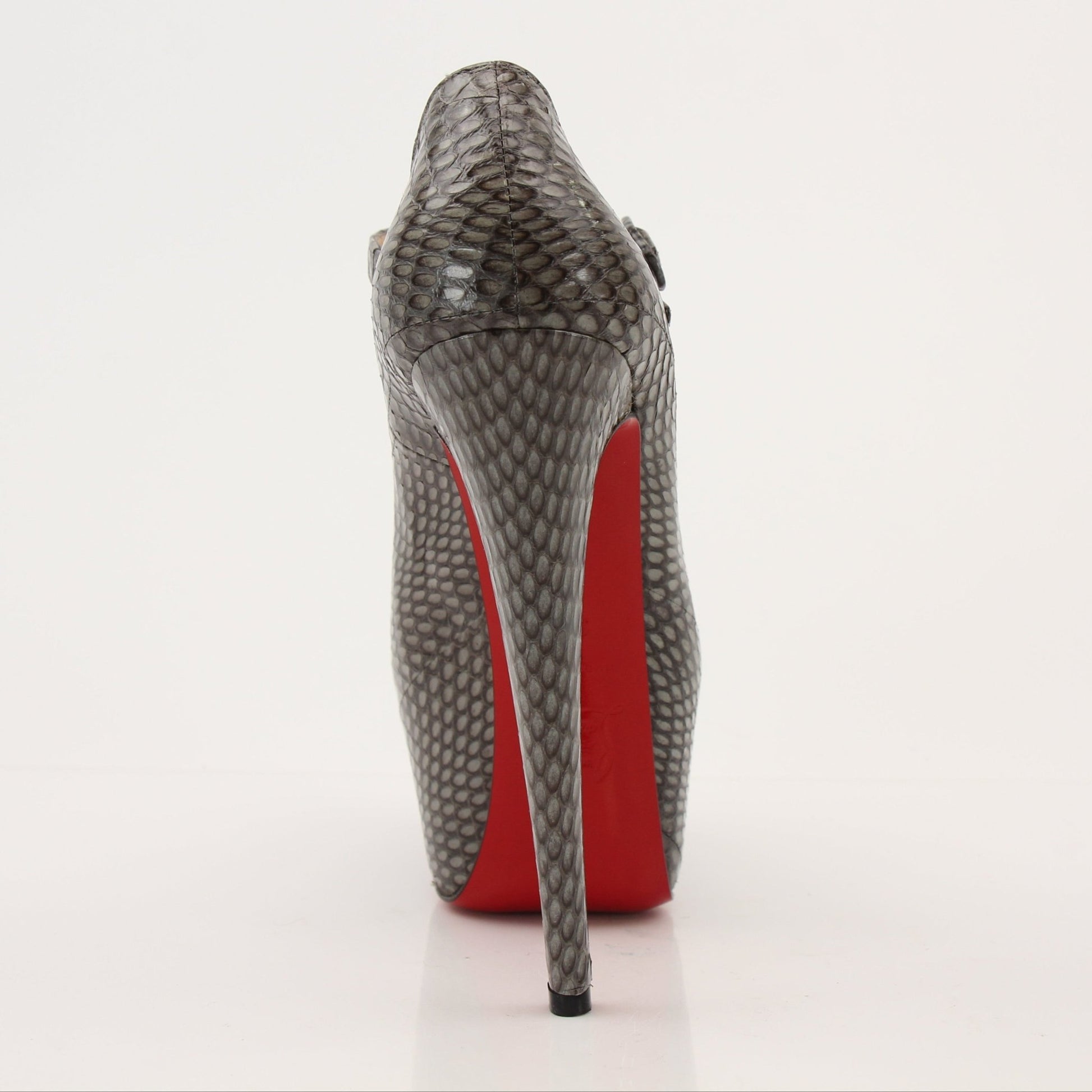Christian Louboutin snakeskin platform heels featuring bold red soles and elegant heel design on a neutral background.