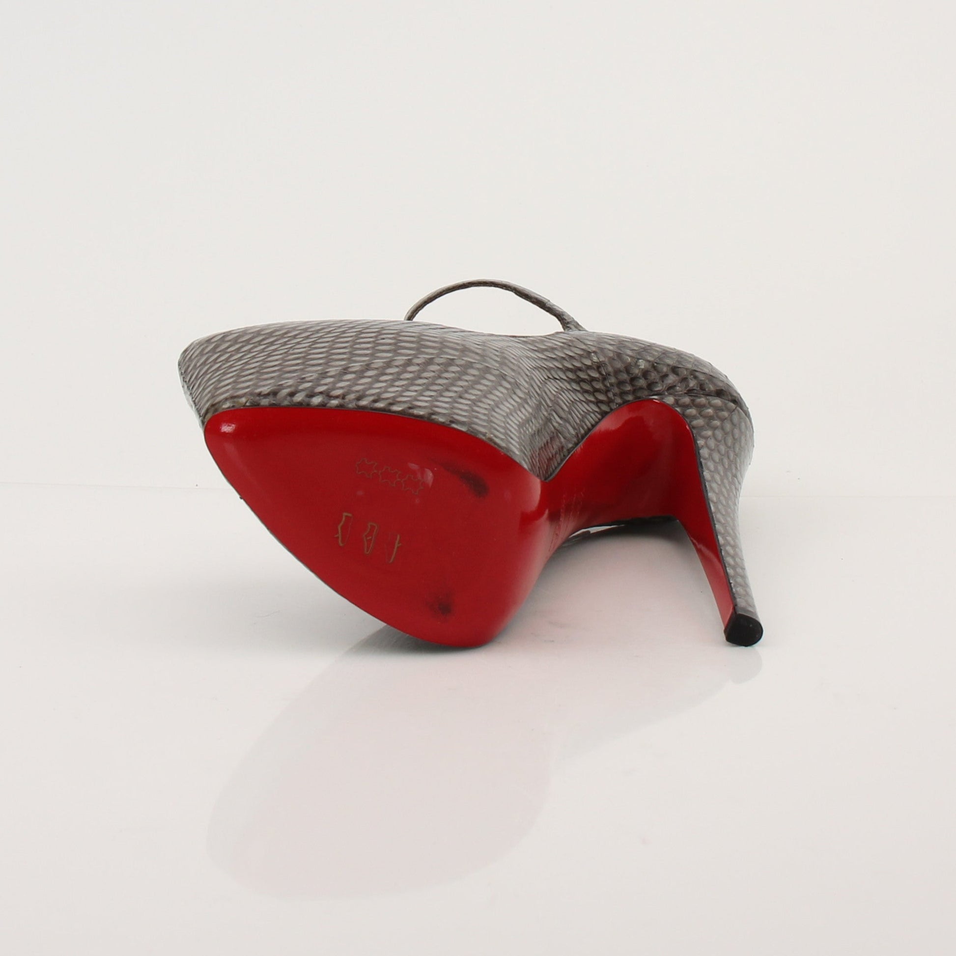Christian Louboutin snakeskin platform heels with red soles and ankle straps, featuring a sleek and stylish design.