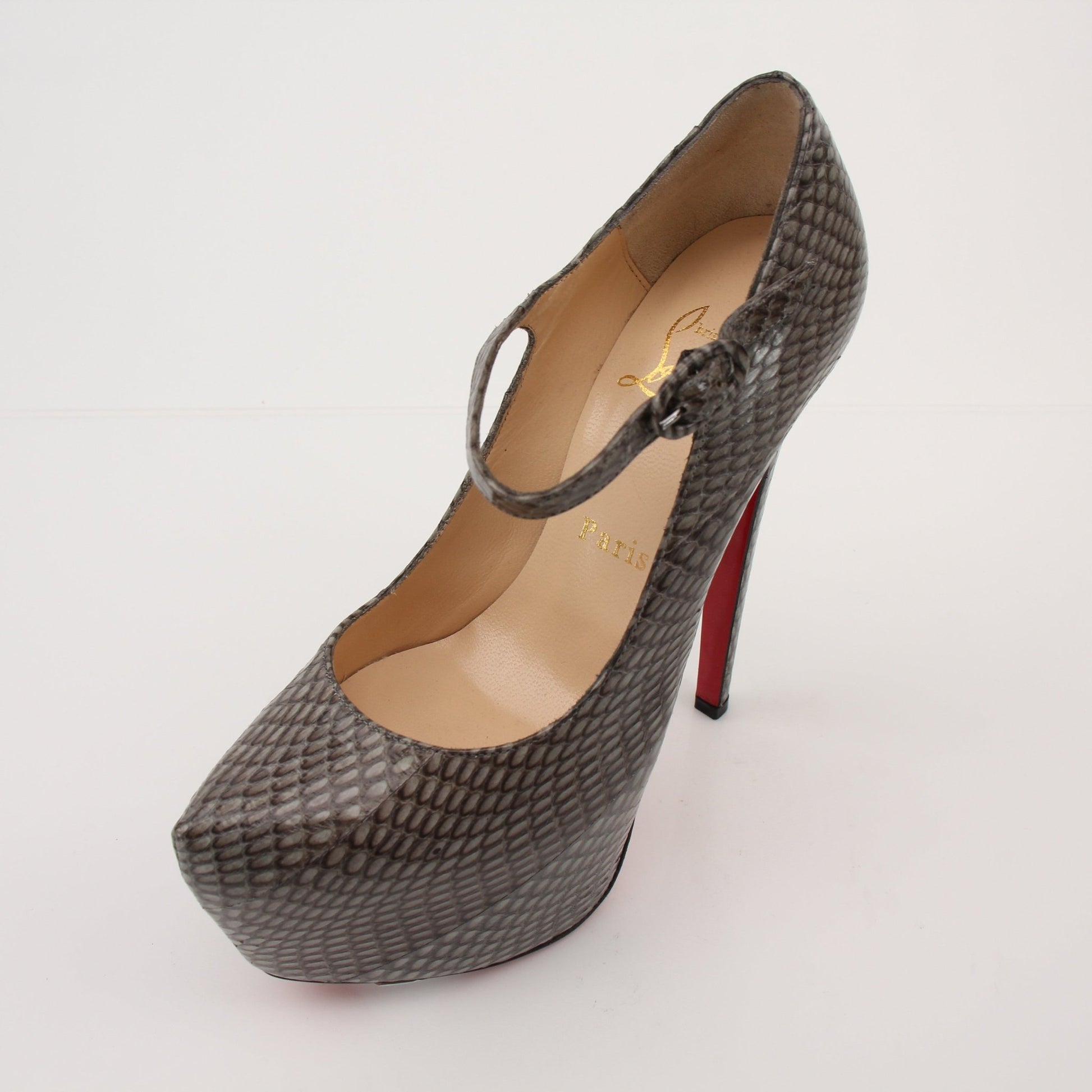 Christian Louboutin snakeskin platform heels with red soles, featuring a sleek design and high stiletto heels.