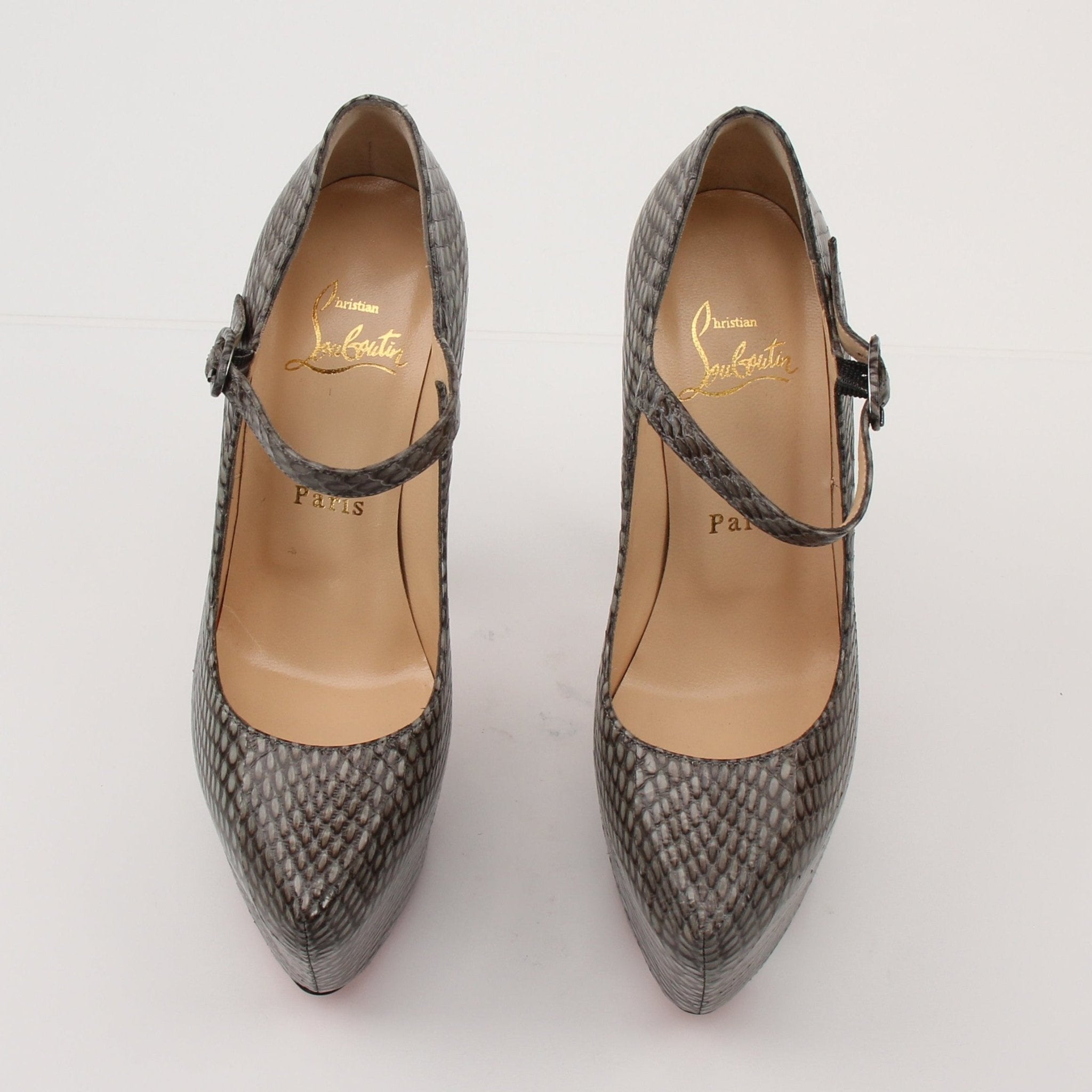 Christian Louboutin snakeskin platform heels with high stiletto heel and red sole, designed for elegant fashion statements.