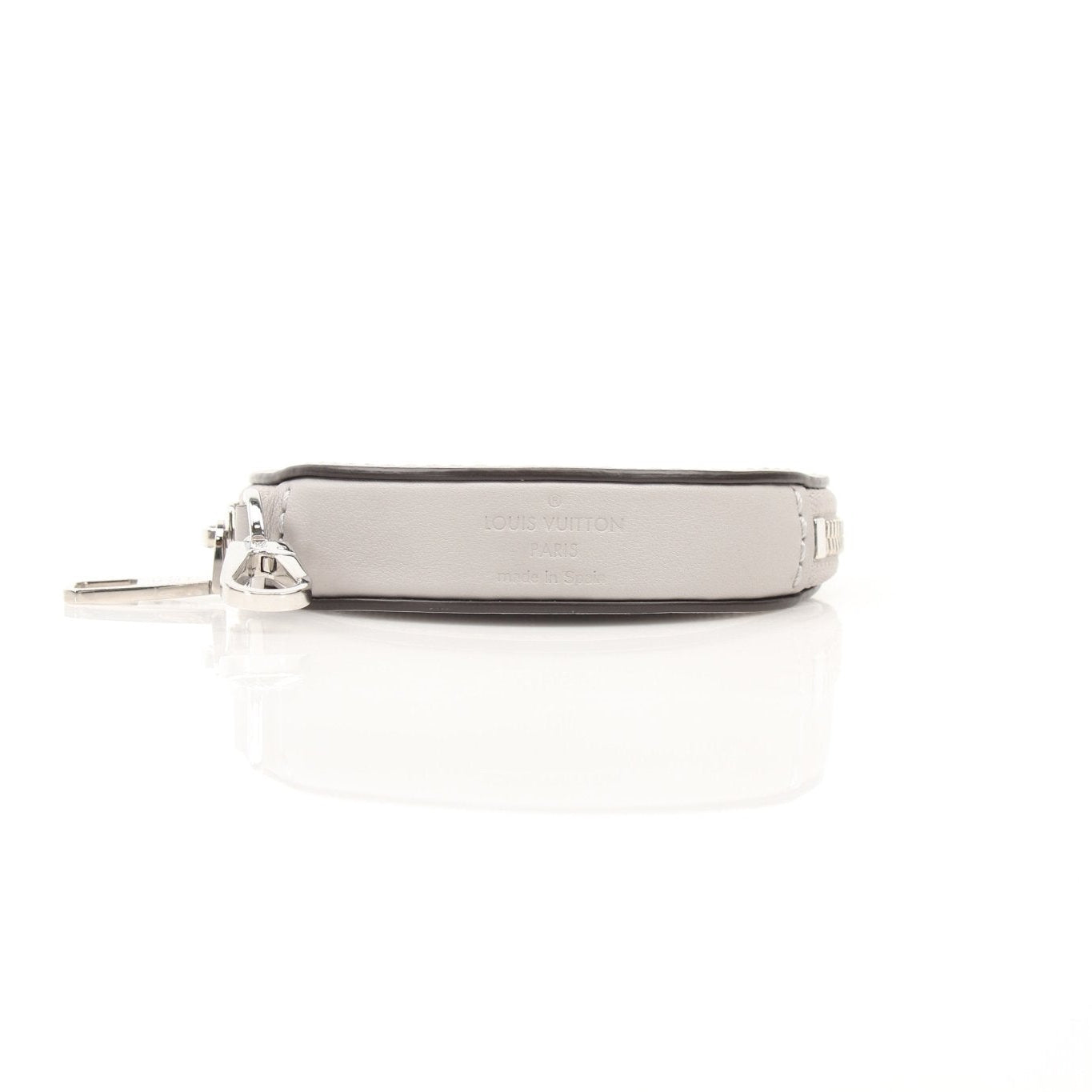 Louis Vuitton gray round bag charm accessory with gold accents, designed to attach to handbags for style and personalization.