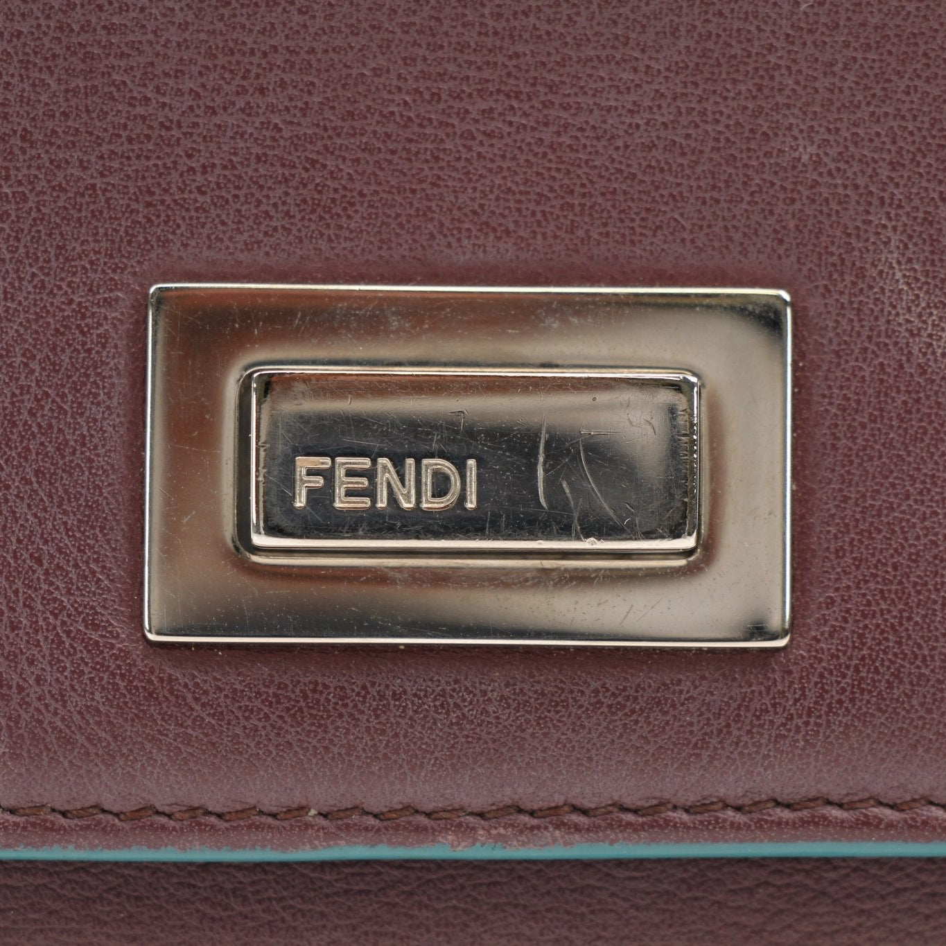 Fendi burgundy continental wallet with gold accents, featuring multiple card slots and a sleek leather finish.