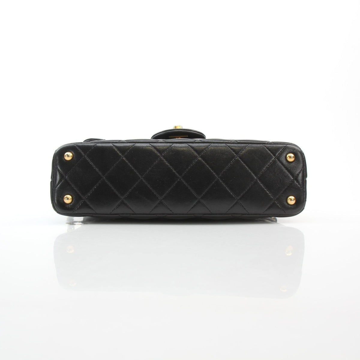 Chanel black lambskin mini flap handbag with top handle, displayed front view