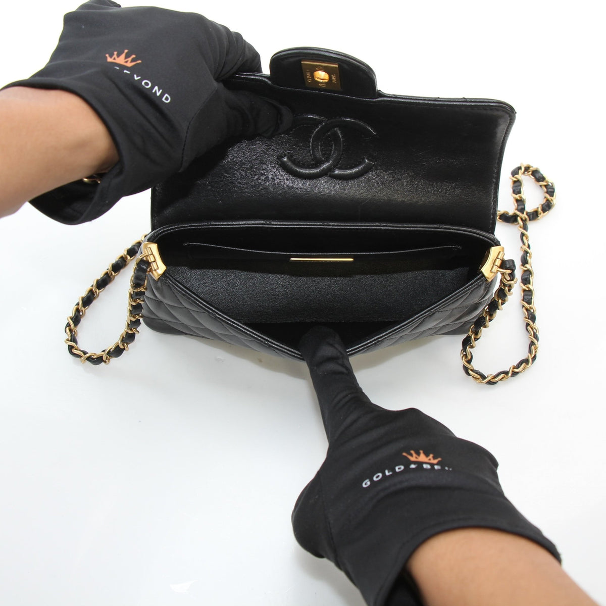 Chanel black lambskin mini flap bag with top handle, showcasing quilted handbag design and gold-tone hardware