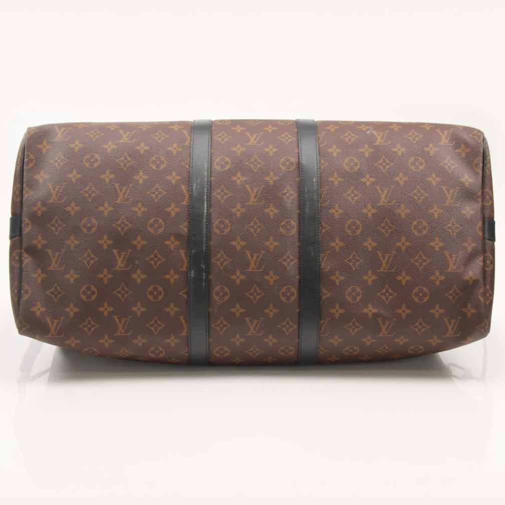 Gold & Beyond Louis Vuitton Keepall Bandoulière 55 travel bag with monogram canvas and leather trim, shown on a flat surface.