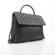 Chanel black caviar leather large Coco Handle flap handbag with structured top handle and chain strap