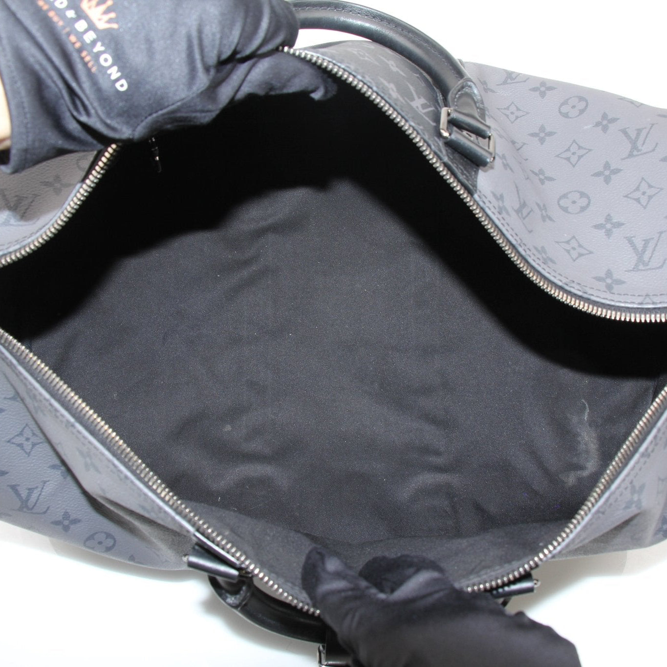 Louis Vuitton Keepall 50 Bandoulière travel bag with leather handles and gold-tone hardware, displayed against a neutral background.