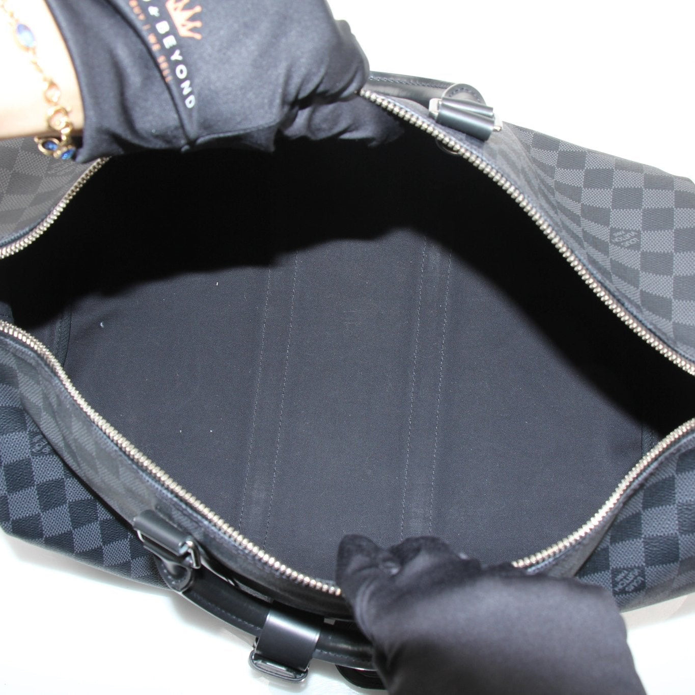 Gold & Beyond Louis Vuitton Keepall 45 travel duffle bag with leather handles and monogram canvas, shown from side view.