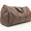 Louis Vuitton Keepall 50 Damier Ebene duffle bag with leather handles and gold hardware, designed for travel and carrying essentials.