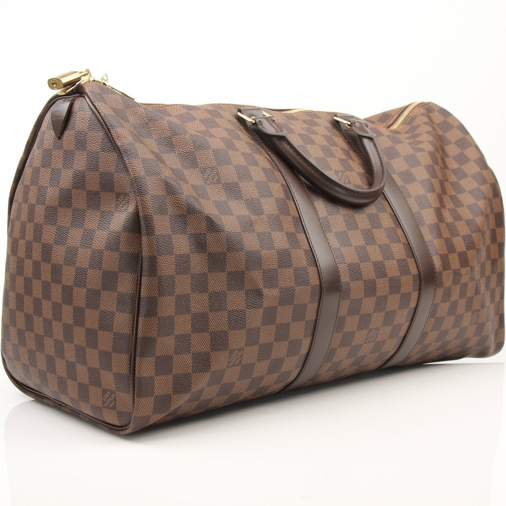 Louis Vuitton Keepall 50 Damier Ebene duffle bag with leather handles and gold hardware, designed for travel and carrying essentials.