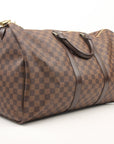 Louis Vuitton Keepall 50 Damier Ebene duffle bag with leather handles and gold hardware, designed for travel and carrying essentials.