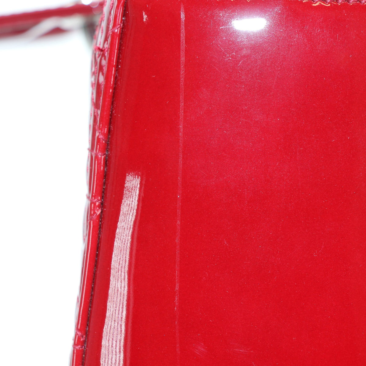 Red patent leather large Lady Dior handbag by Christian Dior, featuring structured top handles and quilted design