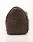 Louis Vuitton Keepall 50 Damier Ebene duffle bag with leather handles and gold hardware, perfect for travel.