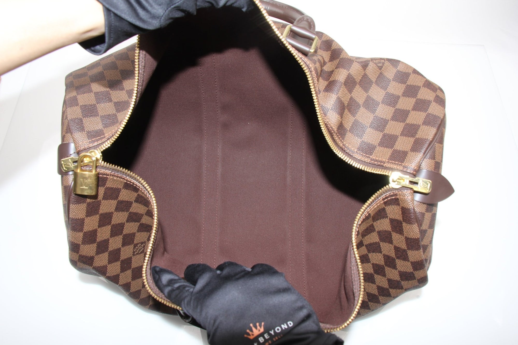 Louis Vuitton Keepall 50 Damier Ebene duffle bag with leather trim, featuring signature checkered pattern and sturdy handles.