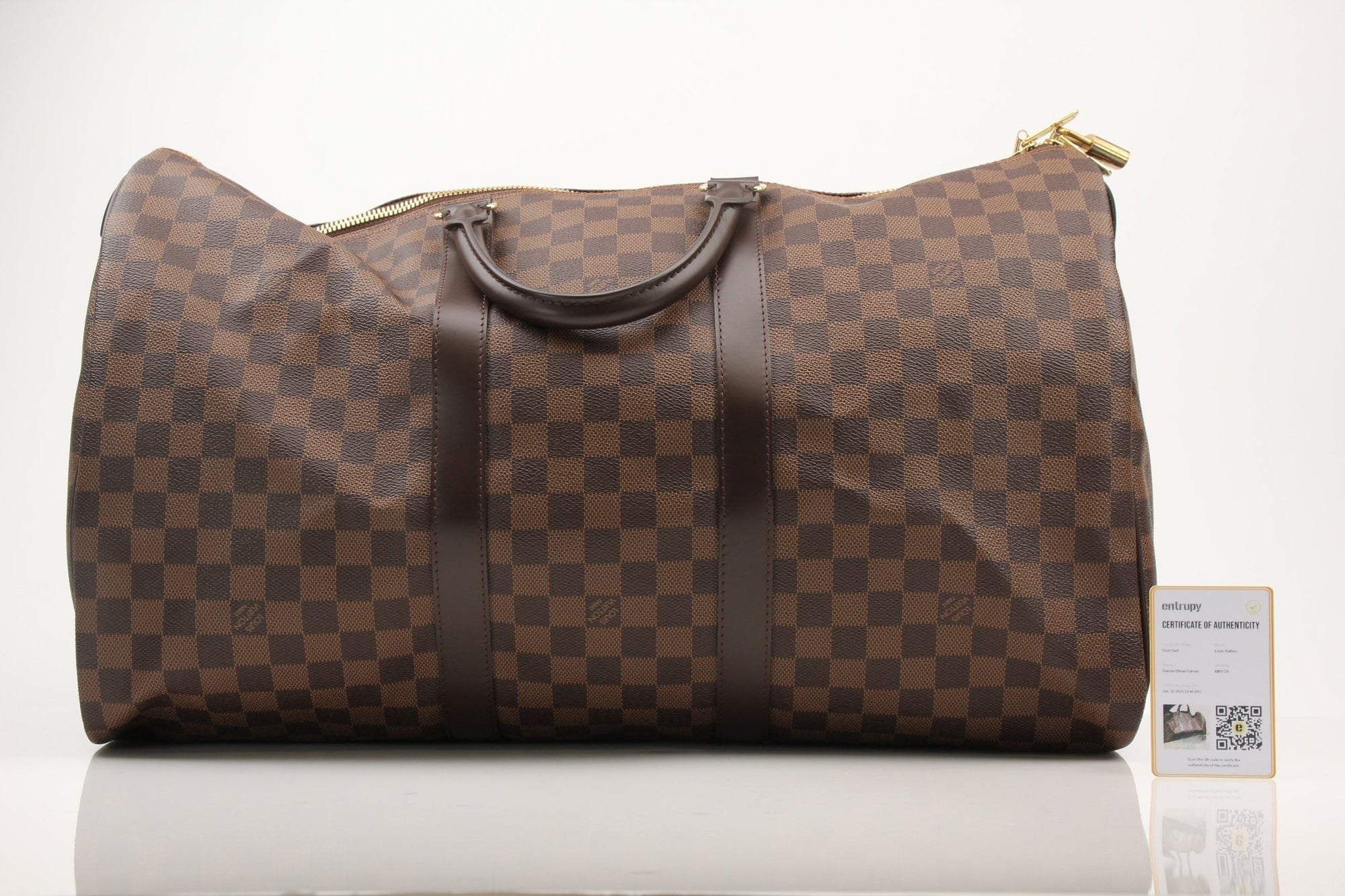 Louis Vuitton Keepall 50 Damier Ebene duffle bag with leather handles and gold hardware, designed for travel and weekend trips.