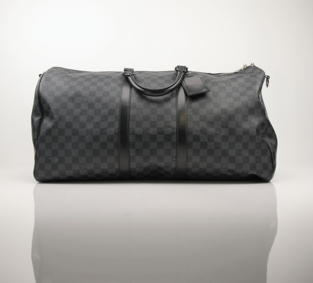 Louis Vuitton Keepall 55 Bandoulière travel bag with leather handles and gold-tone hardware, displayed on a neutral background.