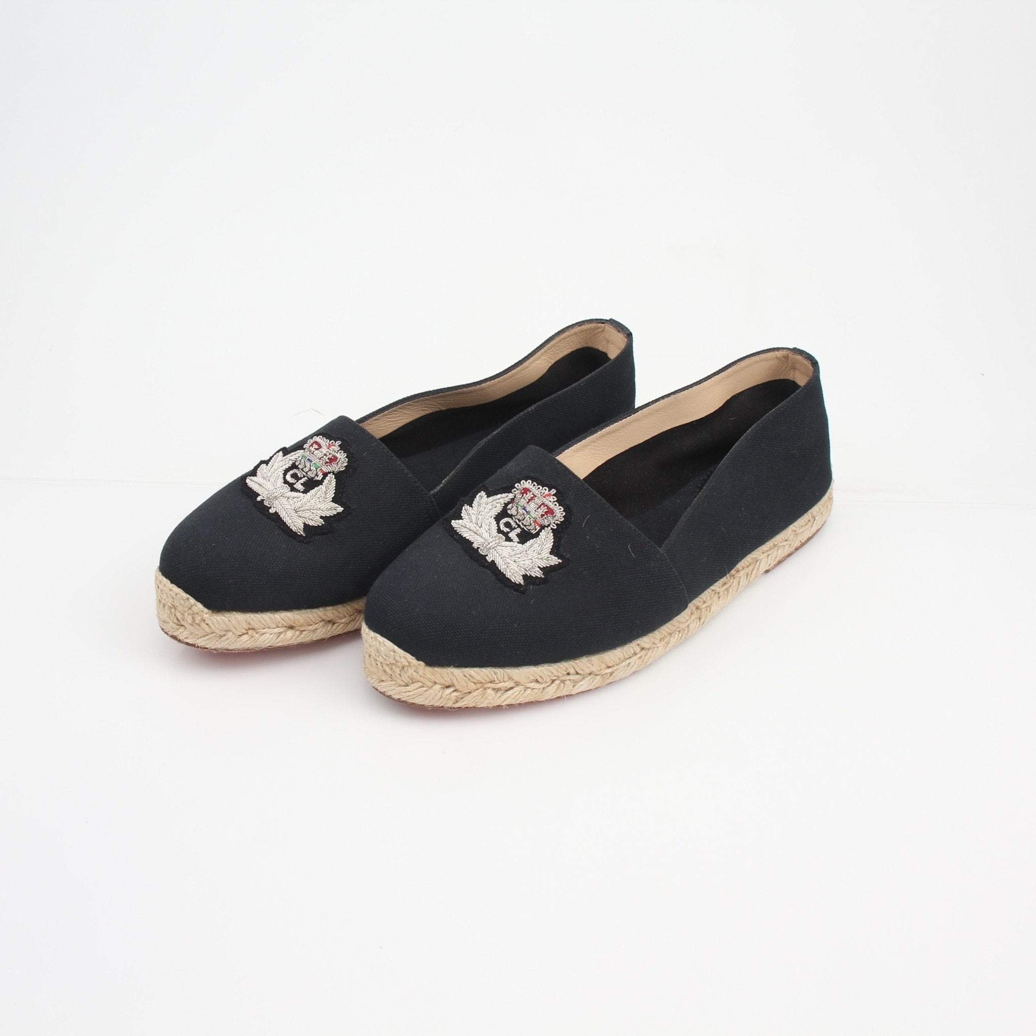 Christian Louboutin embroidered crest canvas espadrille flats showing detailed crest embroidery and classic espadrille sole.
