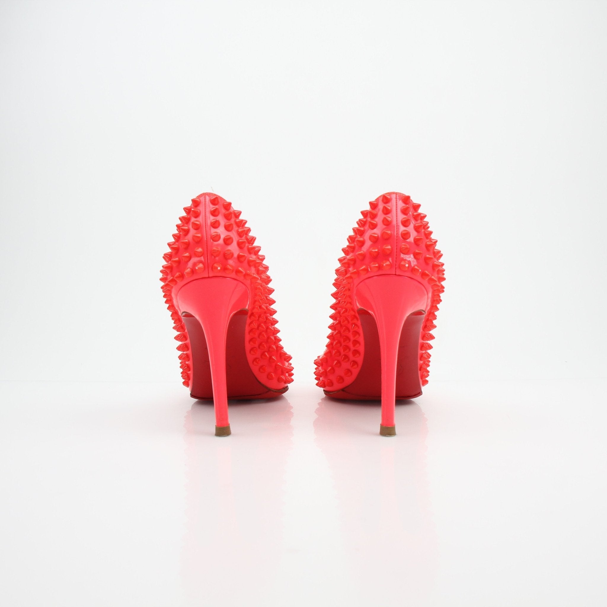 Christian Louboutin So Kate spiked patent leather heels with pointed toes and high stiletto heels, shown in a side view.