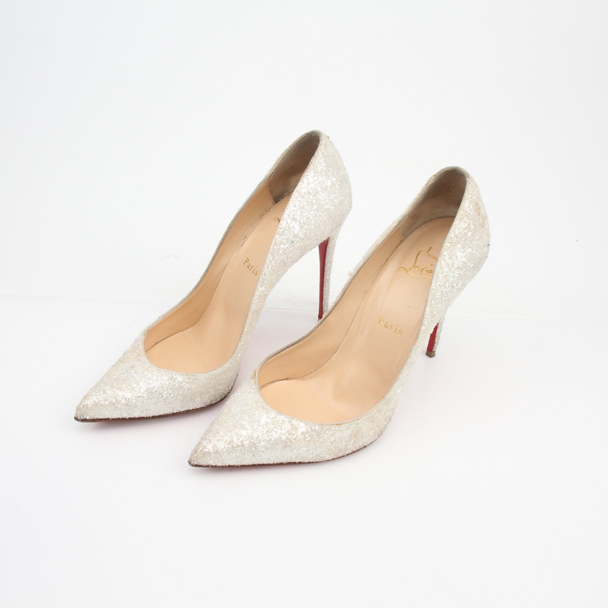 Gold & Beyond Christian Louboutin Pigalle Follies Givre glitter heels with pointed toe and shimmering silver finish on a white background.