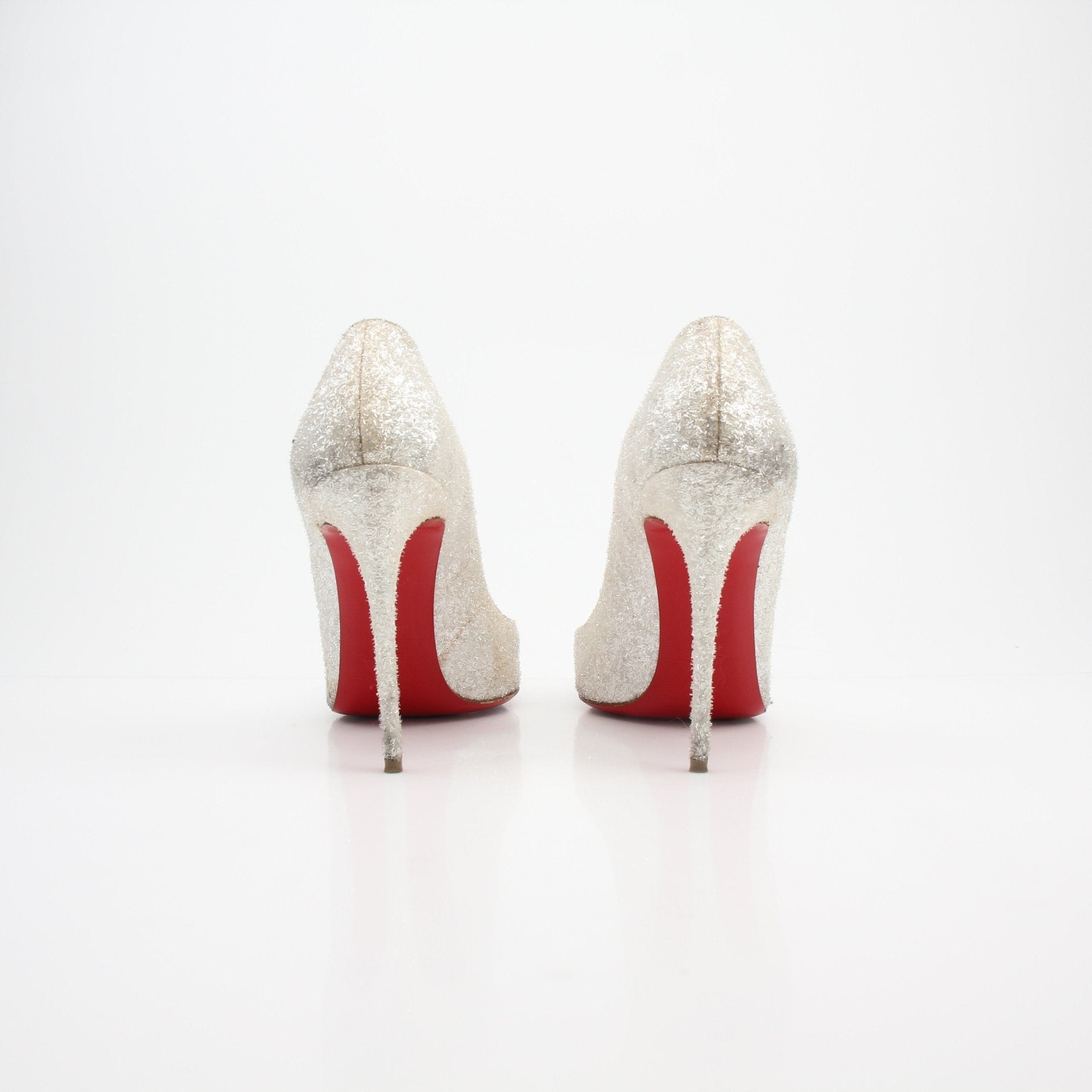 Christian Louboutin Pigalle Follies Givre glitter heels with pointed toes and stiletto heels, featuring shimmering silver glitter finish.