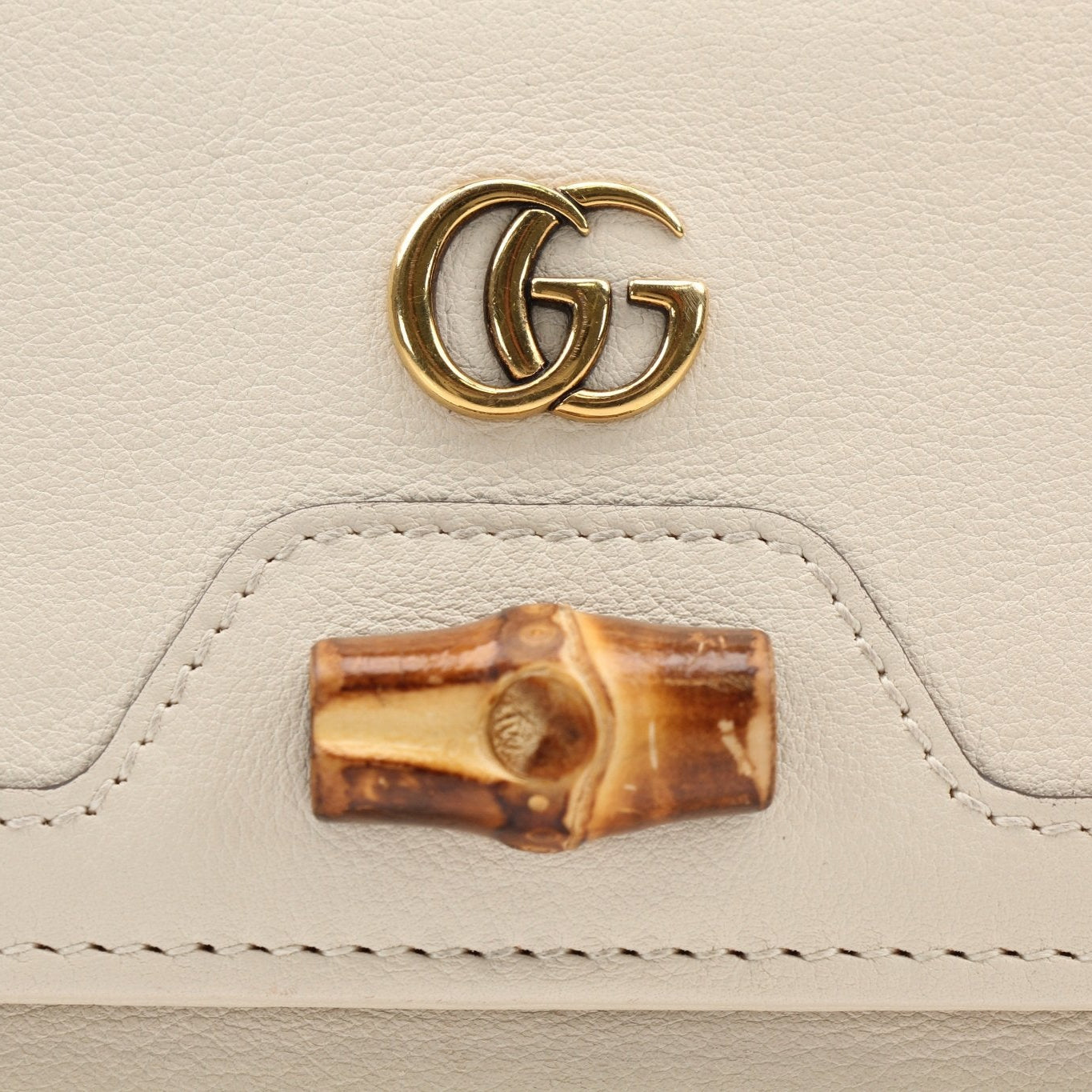 Gucci Diana Wallet by Gold & Beyond, featuring premium leather and gold accents, displayed open showing card slots and interior design.