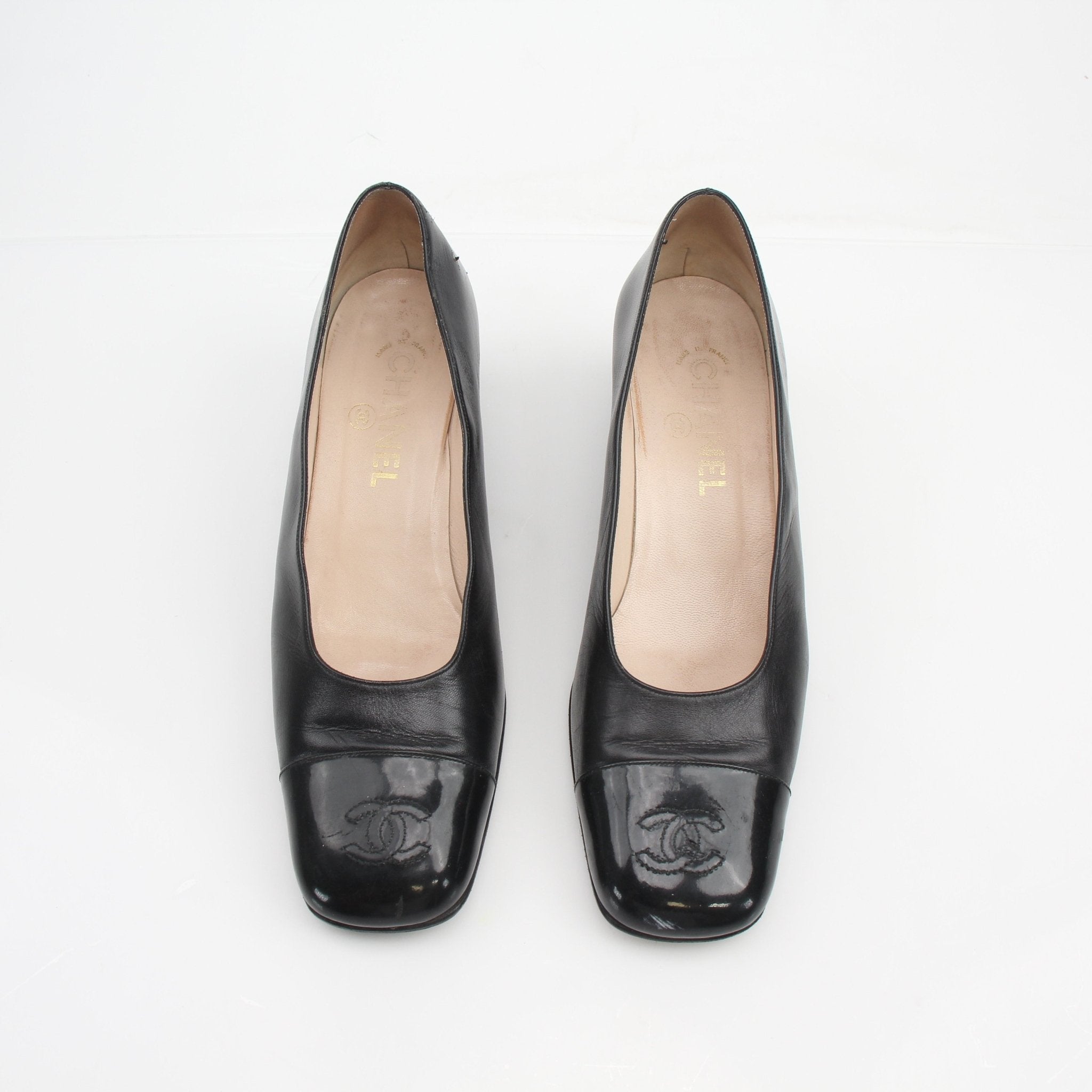 Gold & Beyond Chanel Cap Toe CC Block Heel Pumps, stylish shoes featuring black and beige design with a classic heel.