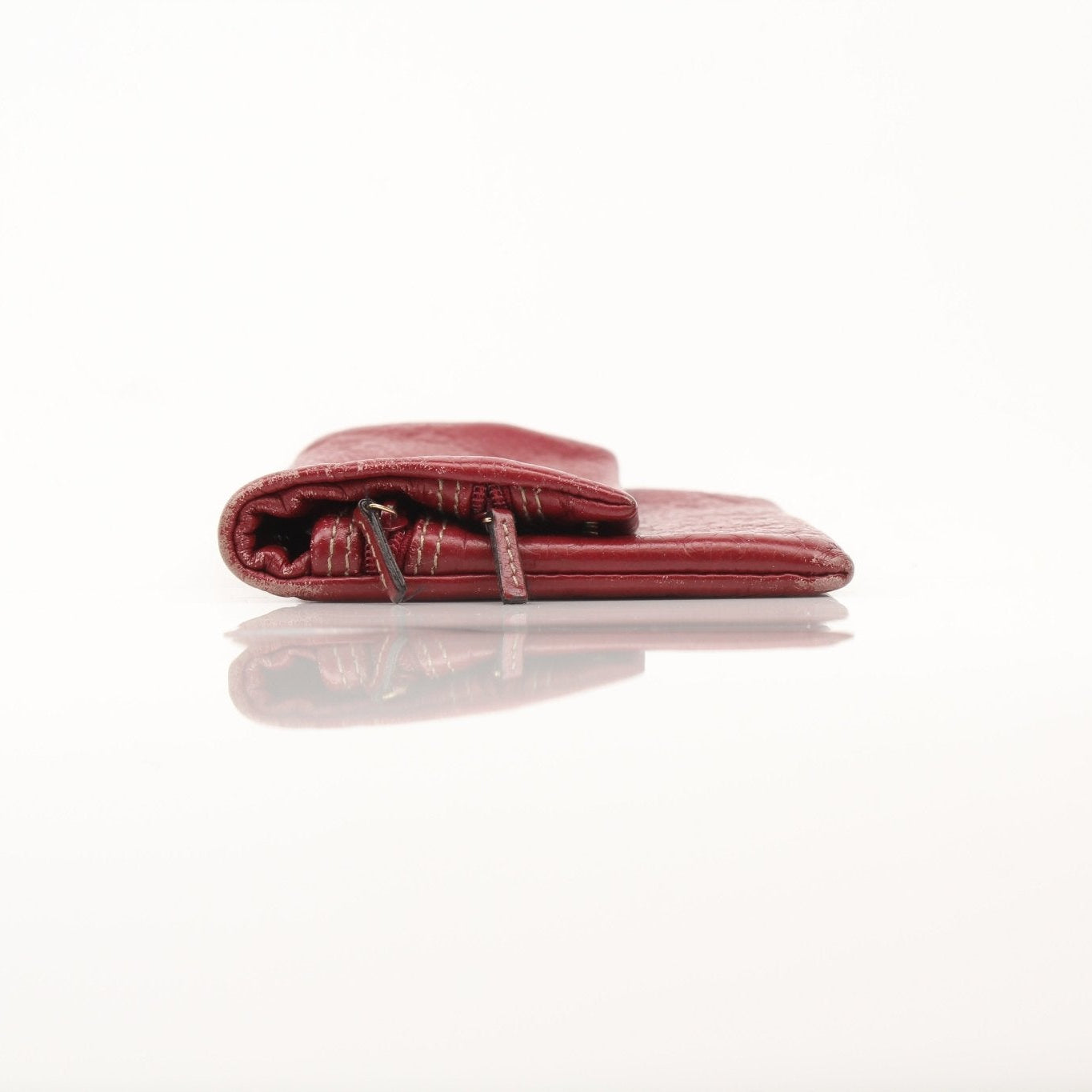 Gucci Guccissima continental wallet in brown leather with gold logo accents, displayed open showing card slots and interior compartments.