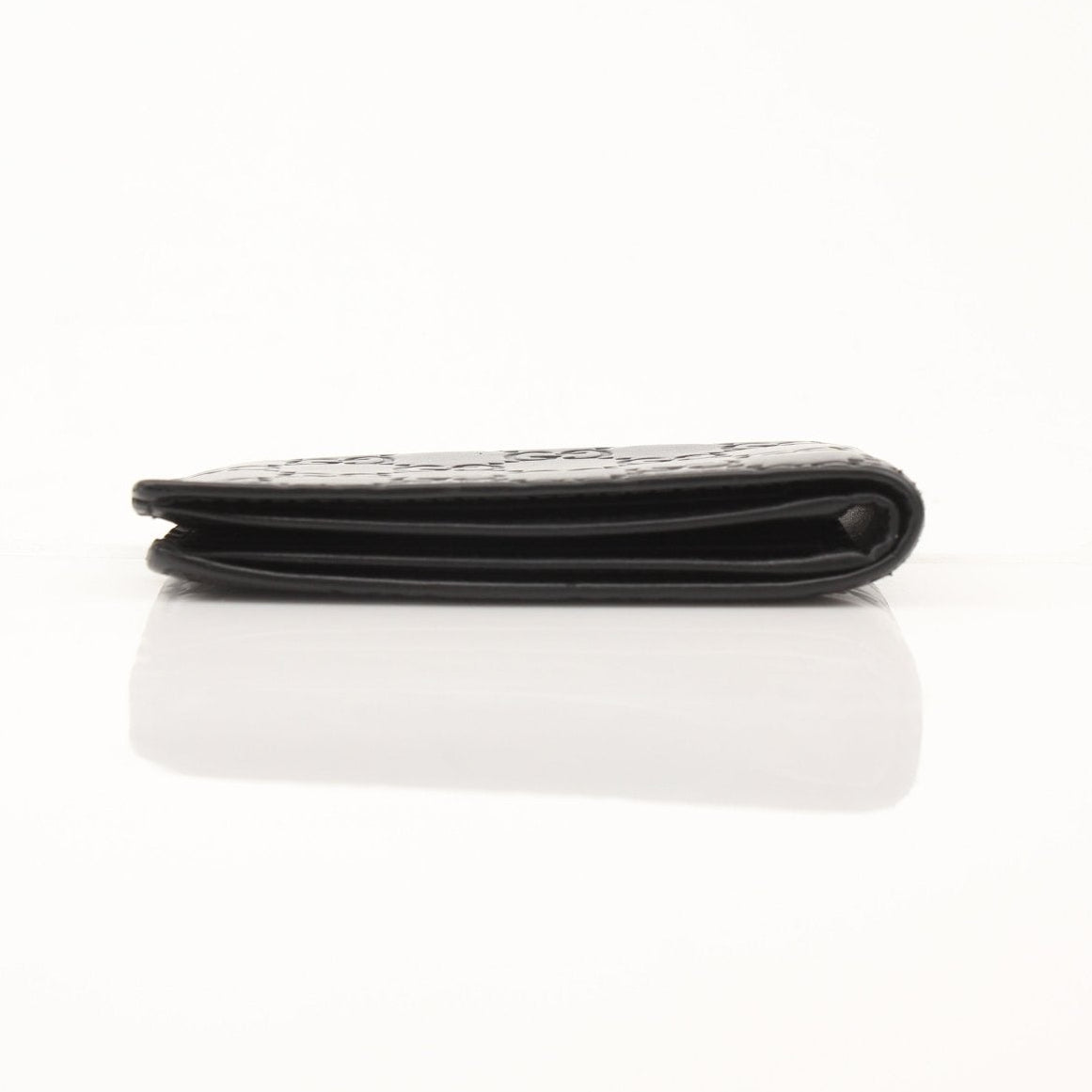 Gold & Beyond Gucci Guccissima bi-fold wallet with embossed pattern, open view showing card slots and interior details.