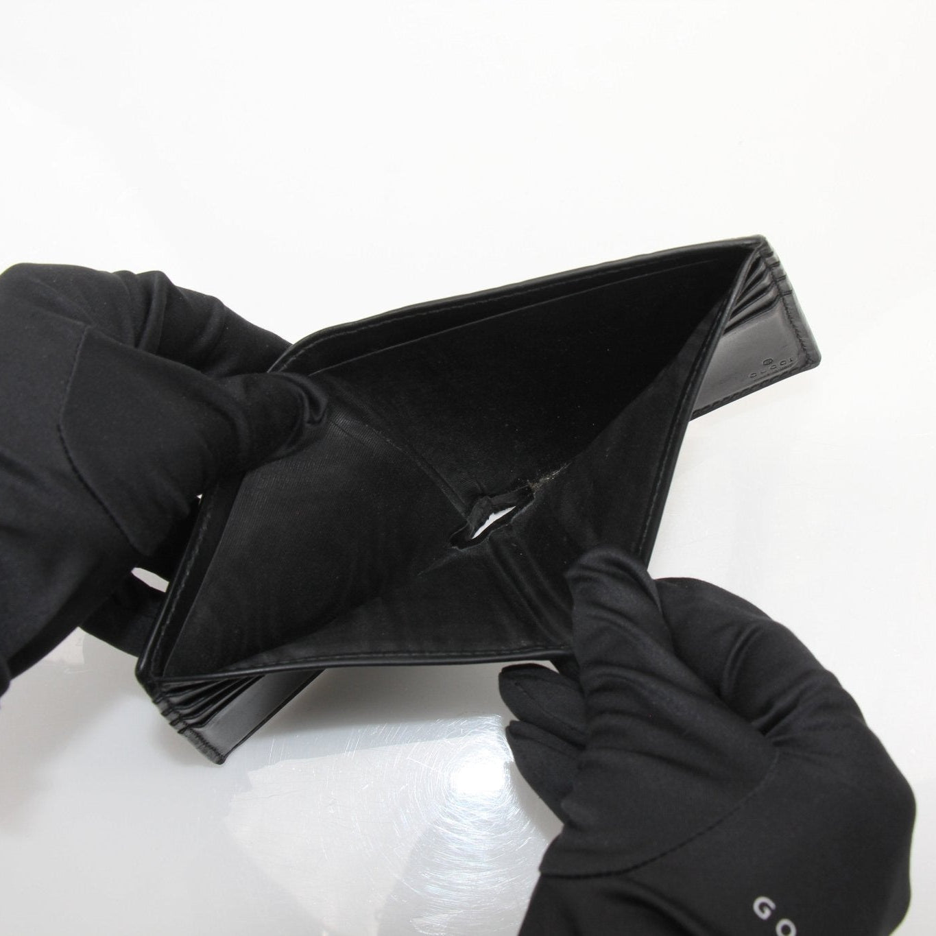 Gold &amp; Beyond Gucci Guccissima bi-fold wallet showing embossed leather with gold-tone accents and multiple card slots.