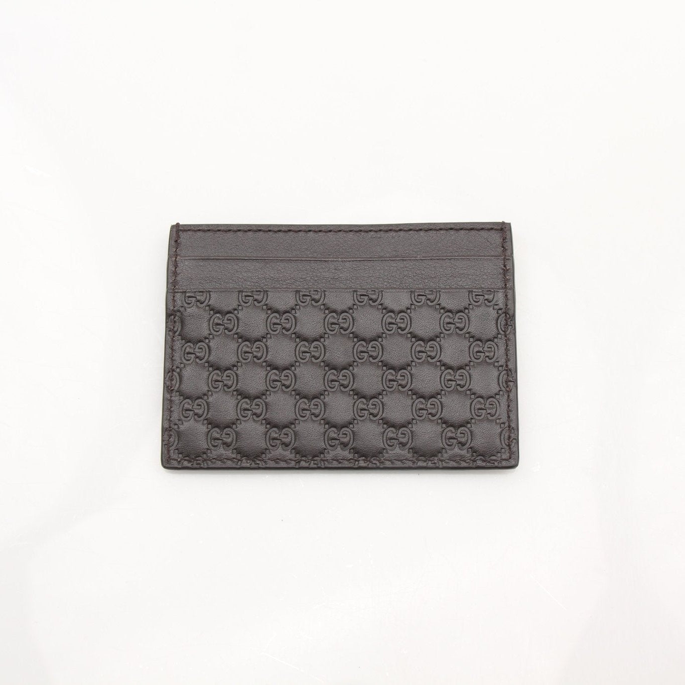 Gold & Beyond Gucci Guccissima leather cardholder wallet with embossed logo and multiple card slots, on a neutral background.