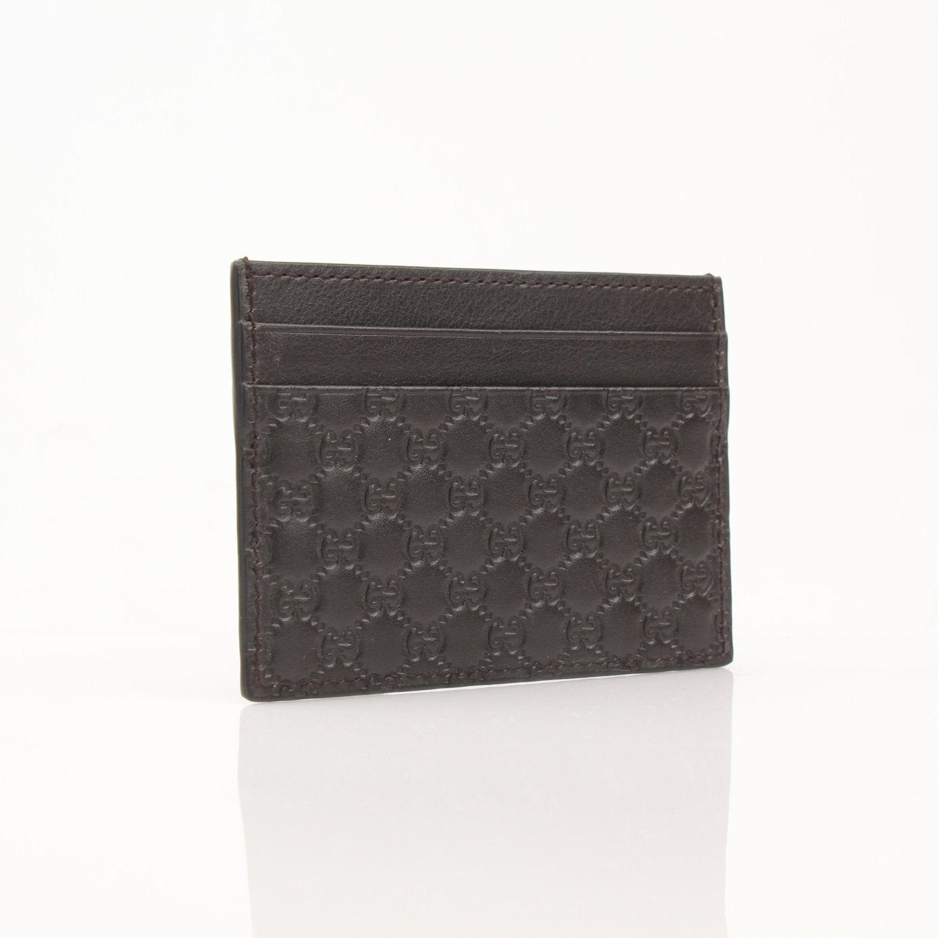 Gucci Guccissima leather cardholder wallet with gold accents, featuring multiple card slots and a sleek design.