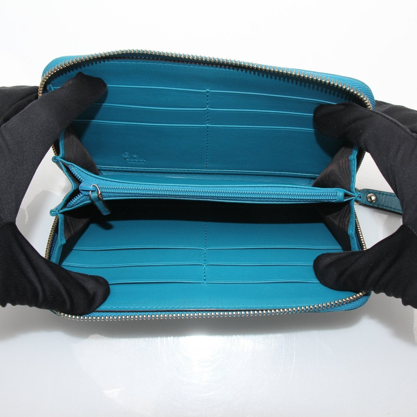 Gold &amp; Beyond Gucci Micro Guccissima wallet with gold-tone hardware, compact design, and signature embossed pattern.