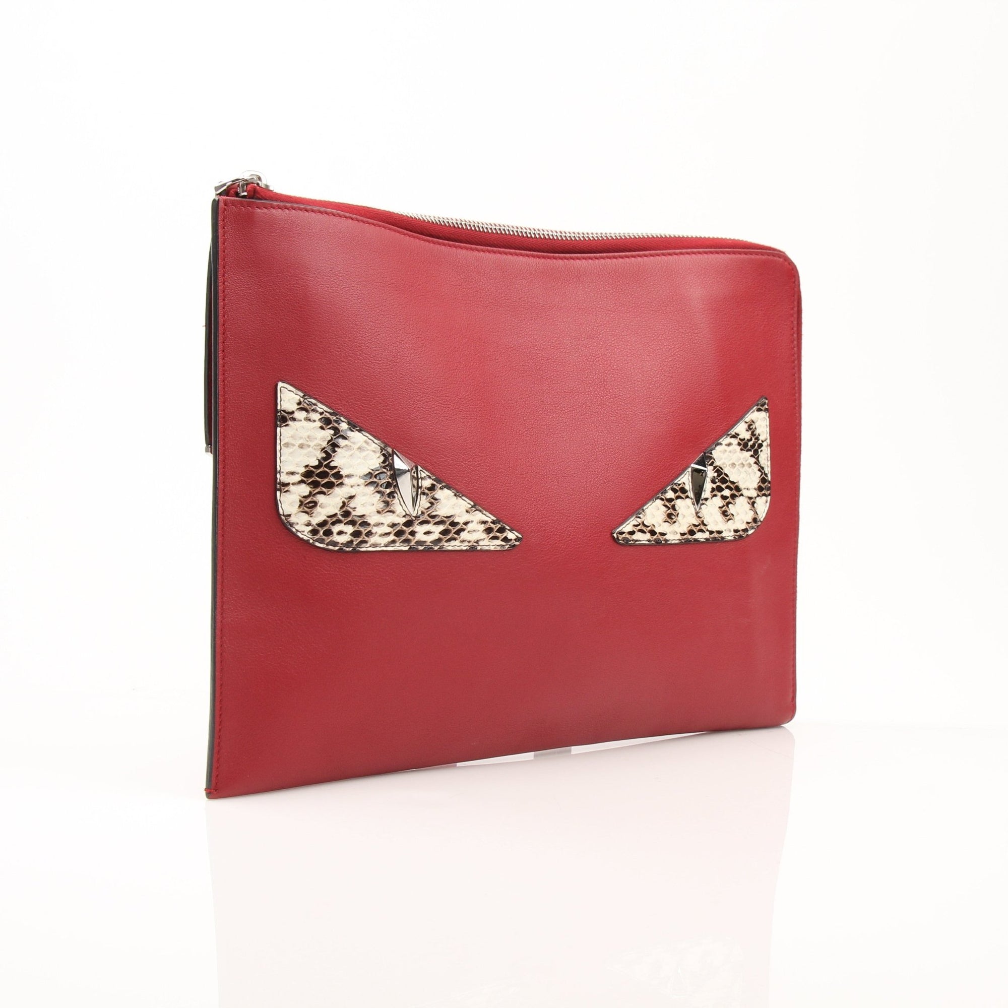 Gold & Beyond Fendi Monster wristlet clutch featuring iconic monster design and wrist strap, stylish accessory for any occasion.