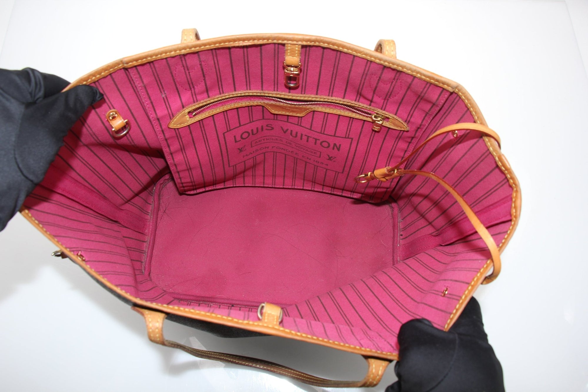 Louis Vuitton Neverfull Monogram tote handbag with leather handles and spacious interior, featuring the iconic LV monogram pattern.