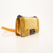 Chanel Small Le Boy Bag in mustard yellow velvet and leather, showcasing its luxurious texture and sleek handbag design.