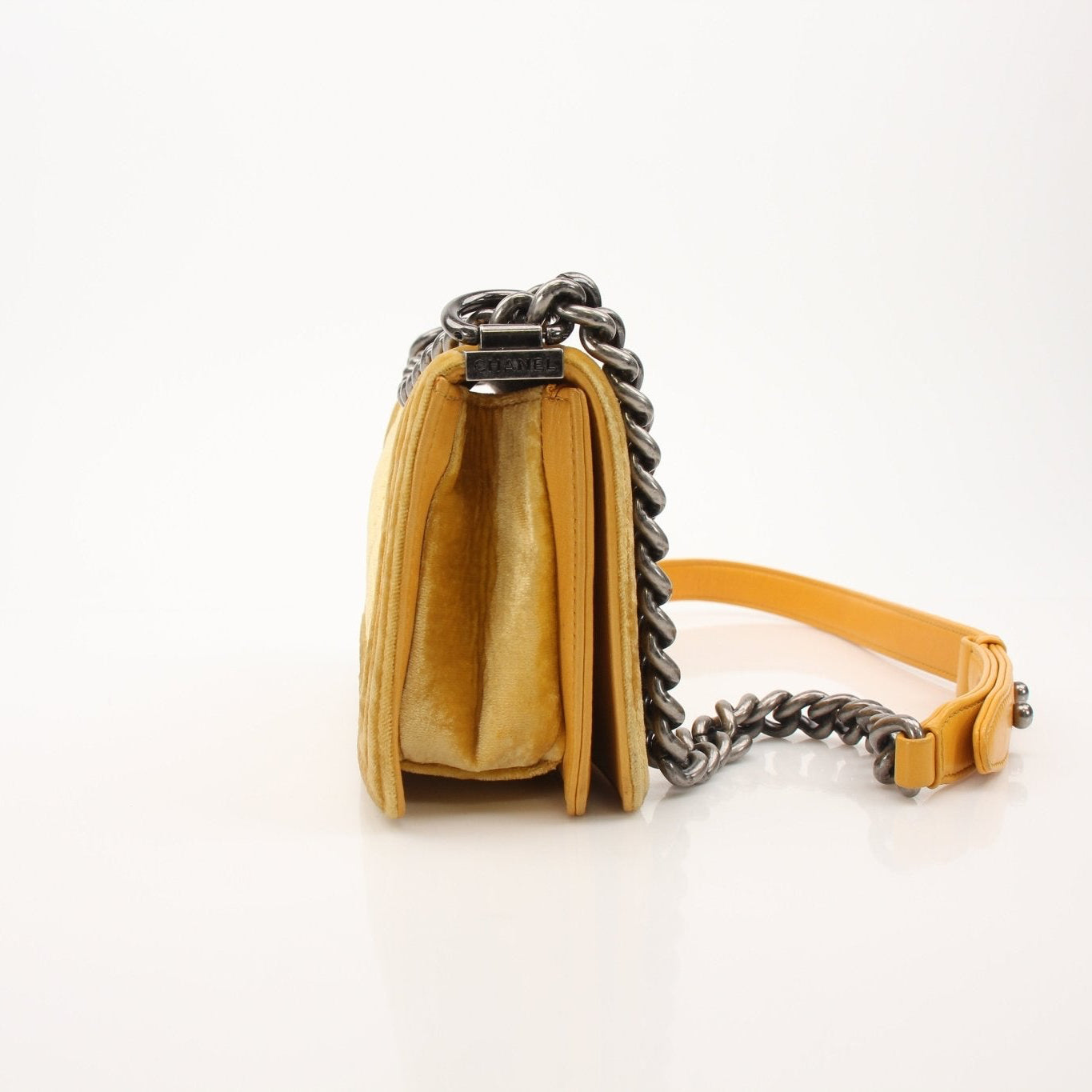 Chanel Small Le Boy Bag in mustard yellow velvet and leather, showcasing its compact handbag design with gold hardware accents.