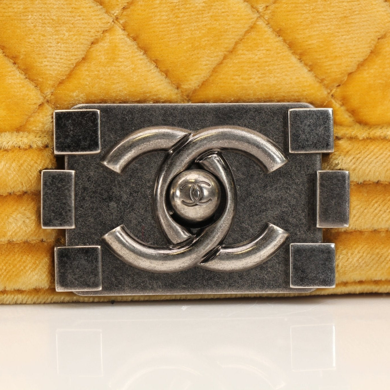 Chanel Small Le Boy Bag in mustard yellow velvet and leather, featuring gold hardware and a chain strap, on a plain background.