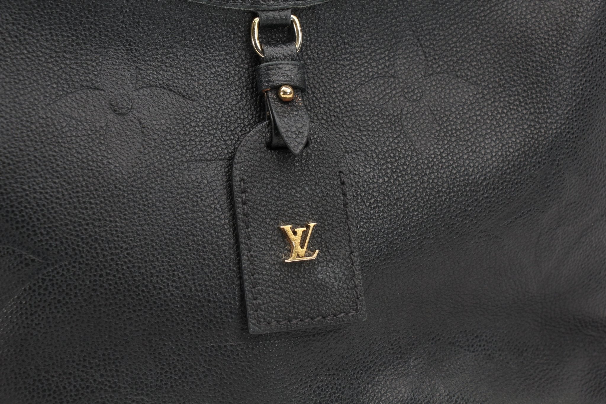 Louis Vuitton Carryall PM handbag in gold with structured design and top handles, showcased in a stylish setting.