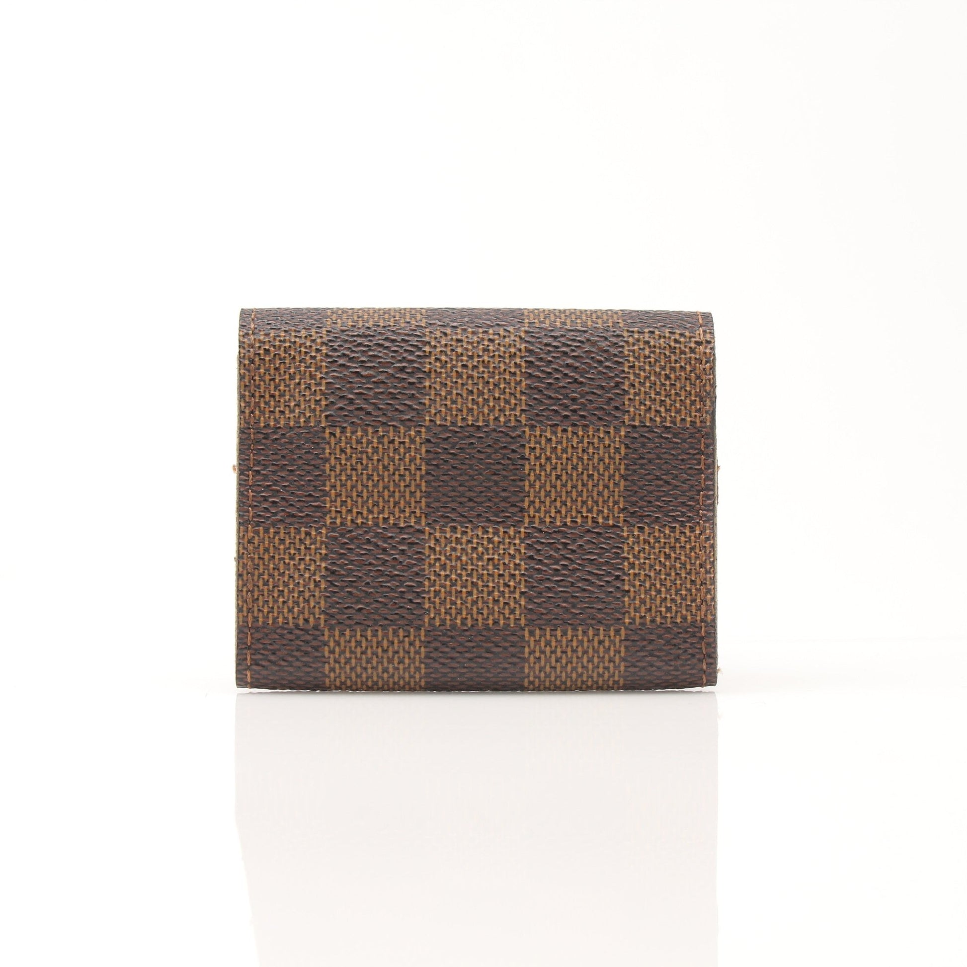 Louis Vuitton Damier Ebene key holder pouch with gold hardware, featuring a classic checkered pattern and compact accessory design.
