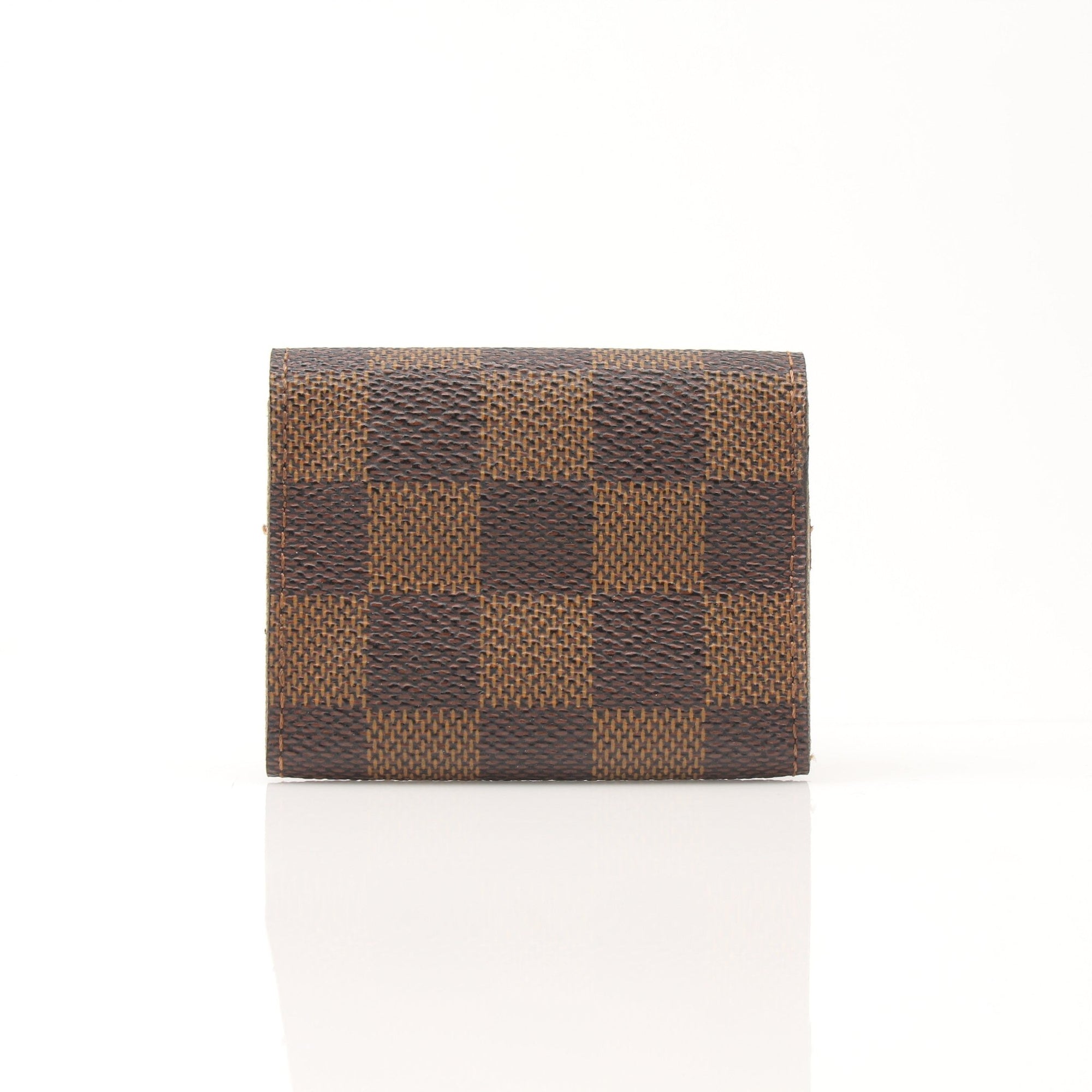 Louis Vuitton Damier Ebene key holder pouch with gold accents, showcasing the signature checkered pattern and compact accessory design.