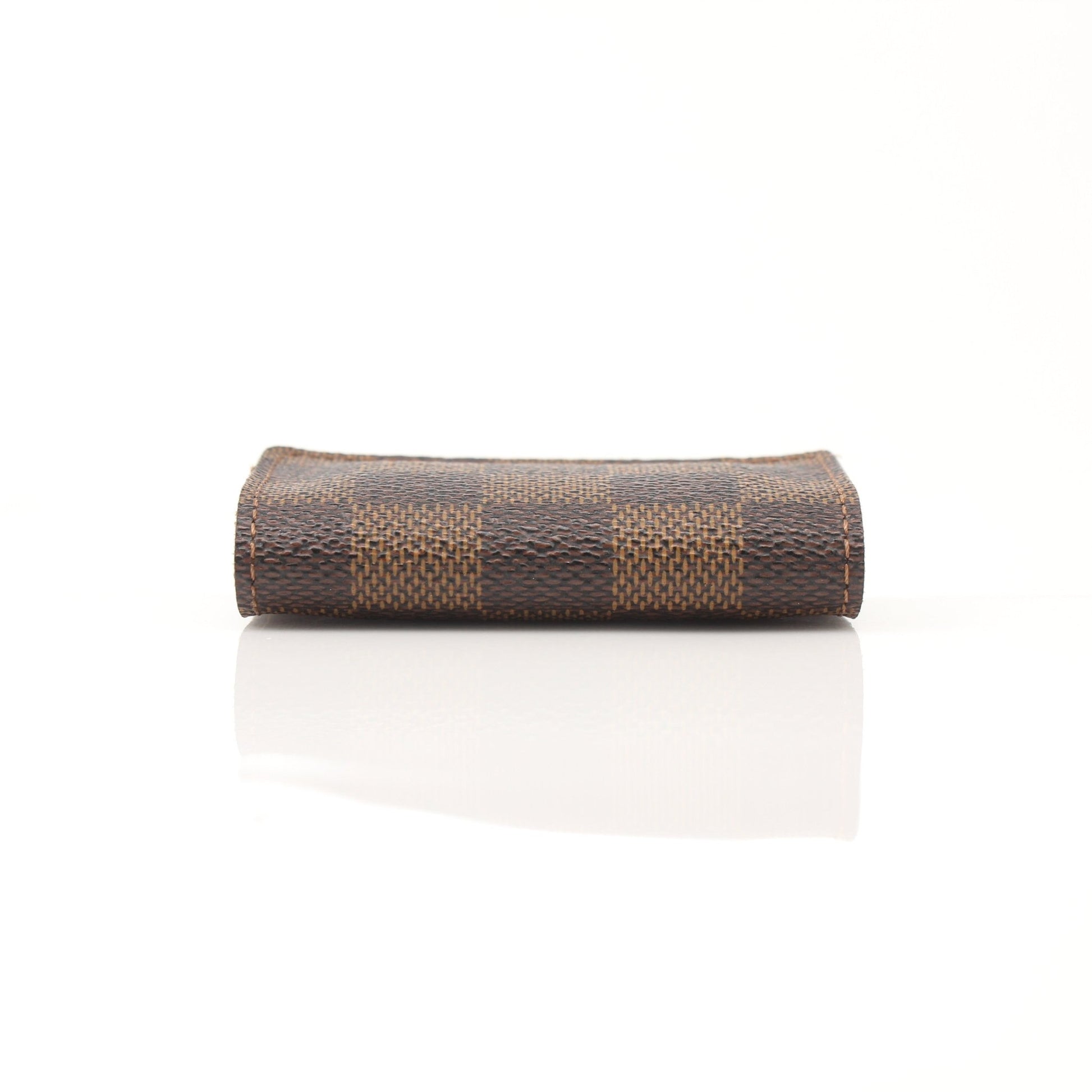 Louis Vuitton Damier Ebene key holder pouch with gold-tone hardware, featuring the signature checkered pattern and compact design.